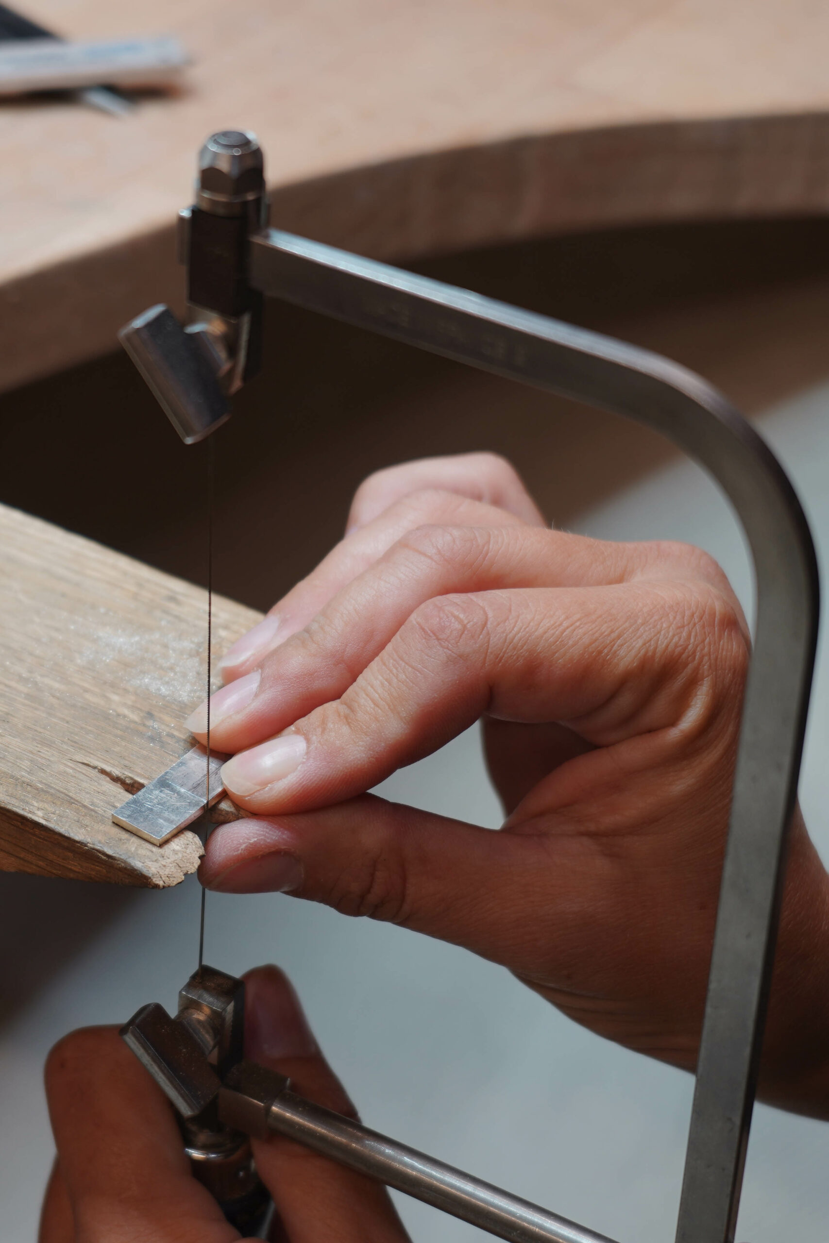 basic jewellery work hand sawing of the piece of the metal.