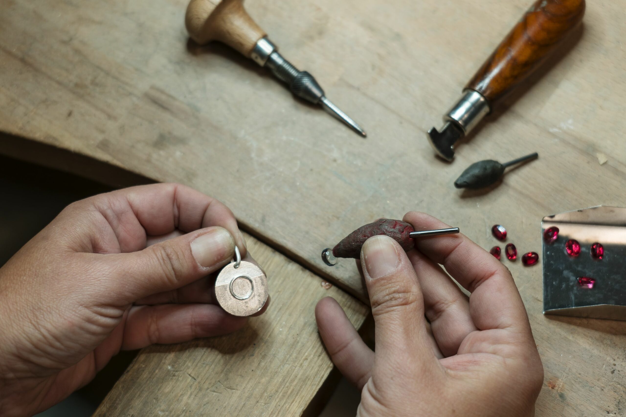 stonesetter making a bezel set of the blue topaz stone on the si
